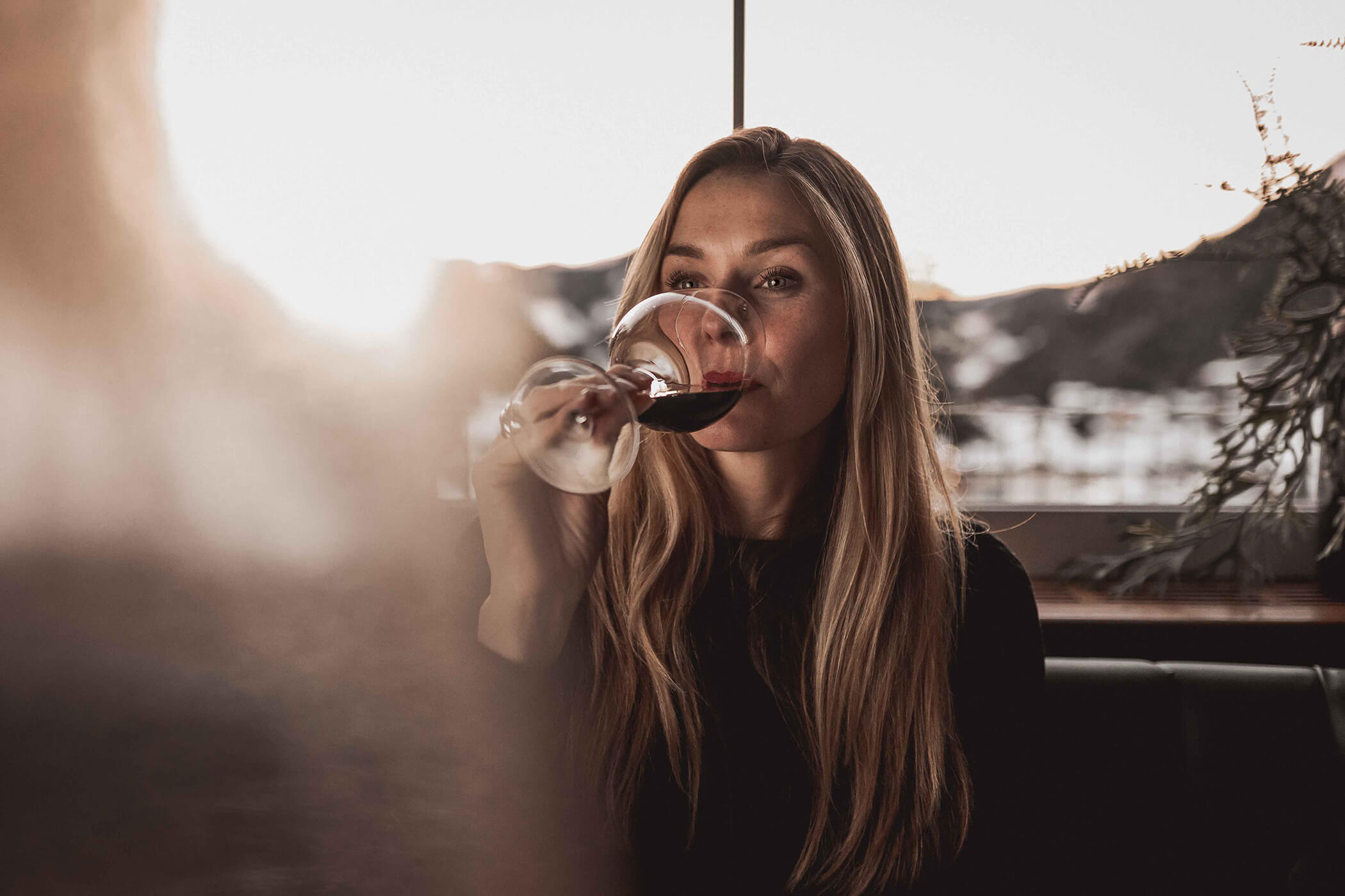 Woman enjoying her red wine in the dining room in the evening - Hotel Continental