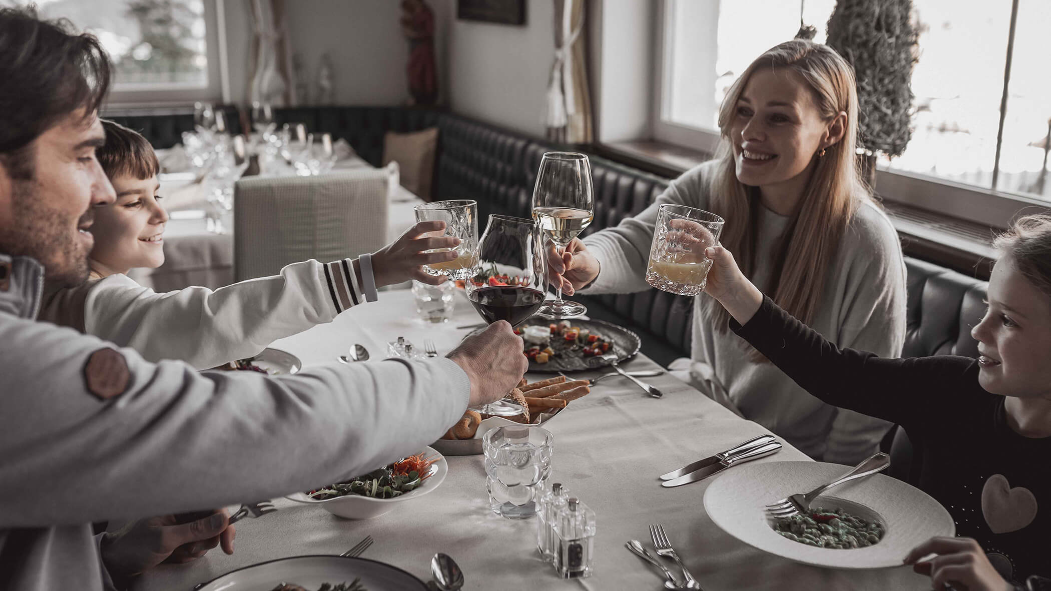 Familie am Mittagstisch beim Anstoßen - Hotel Continental