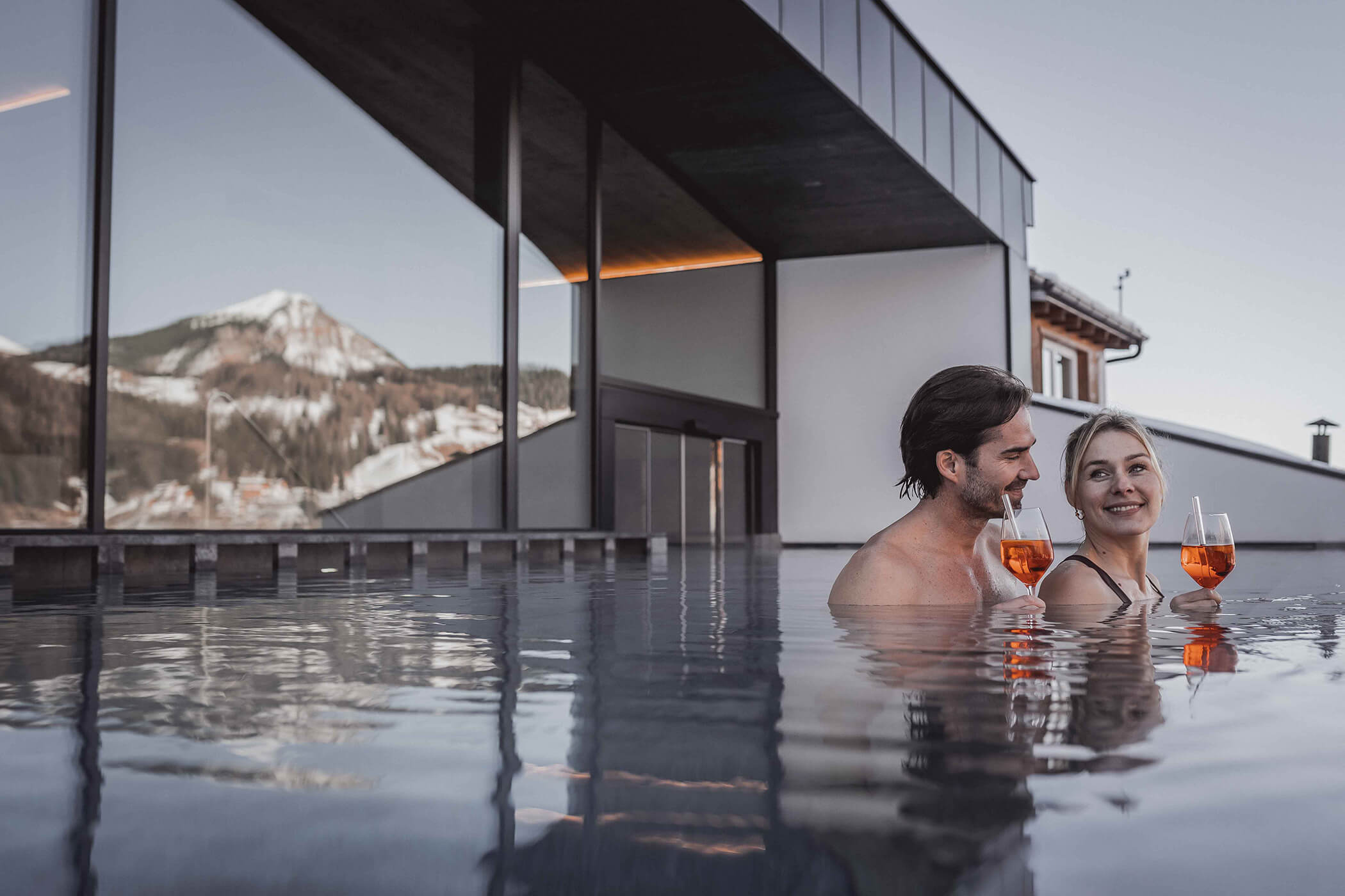 A couple with two Aperol Spritz in their hands in the infinity pool - Hotel Continental
