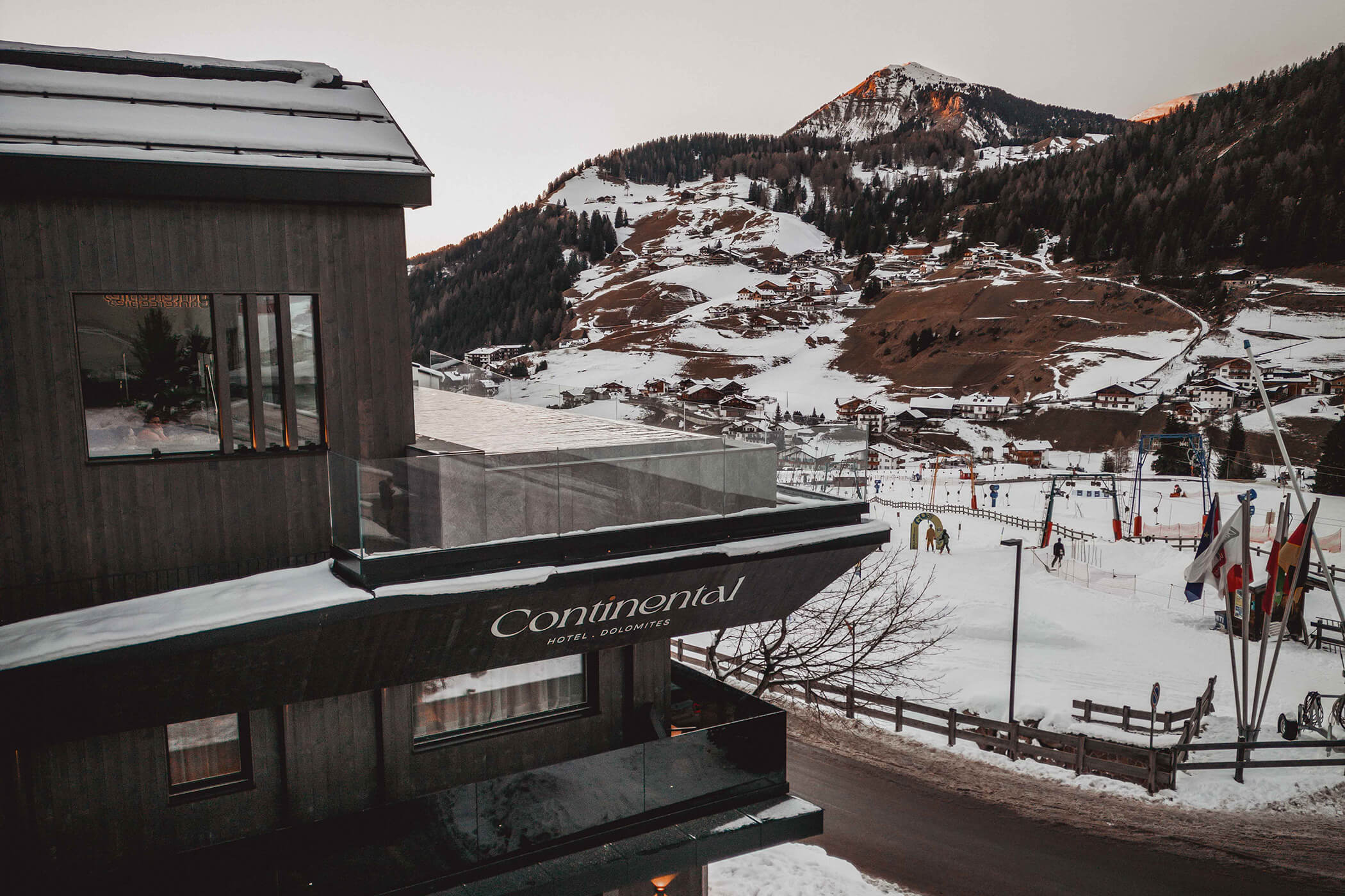The Hotel Continental with infinity pool, the elevator next to it and the mountains in the background