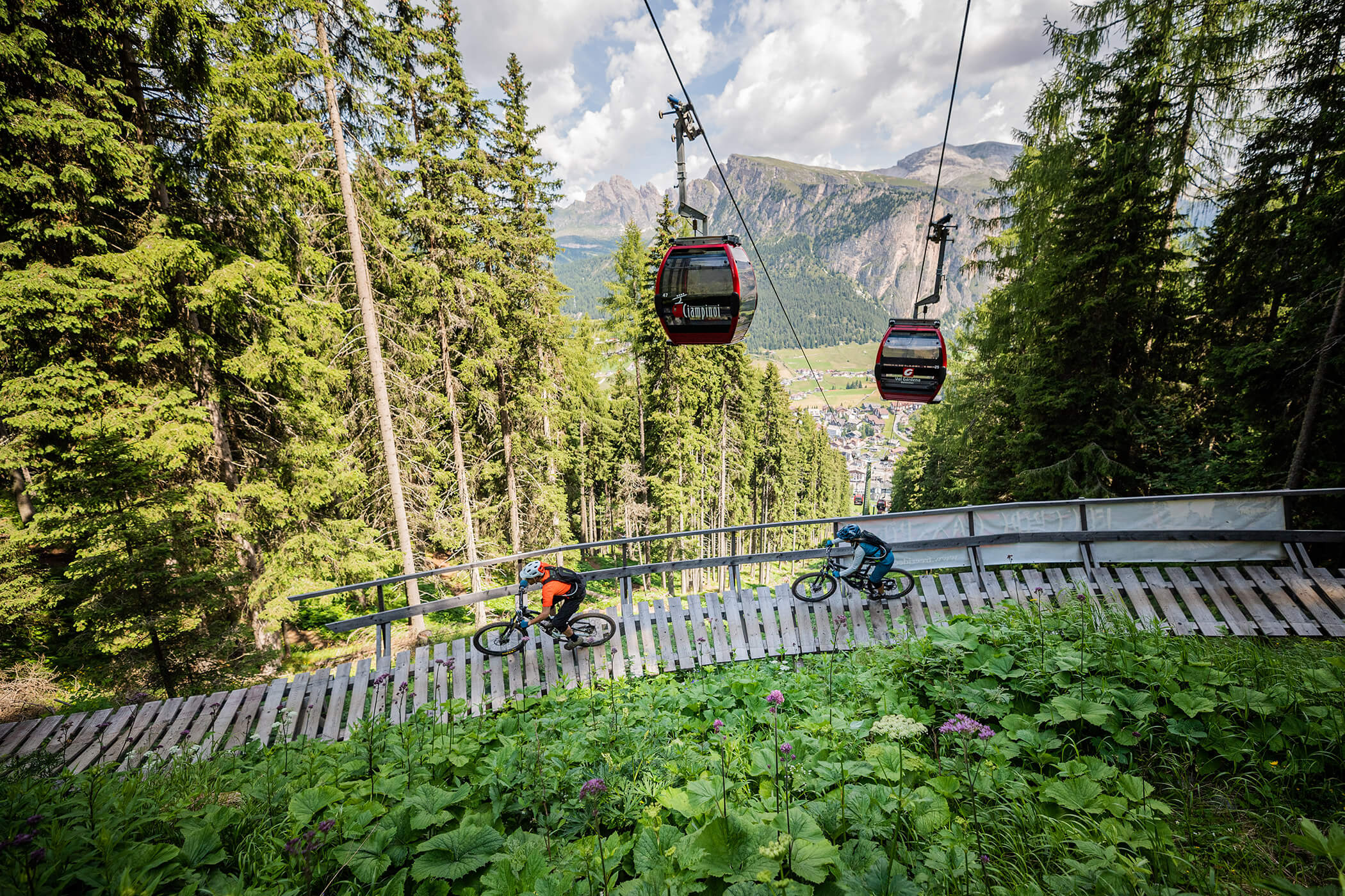 Two mountain bikers on the bridge and two gondolas above - Hotel Continental