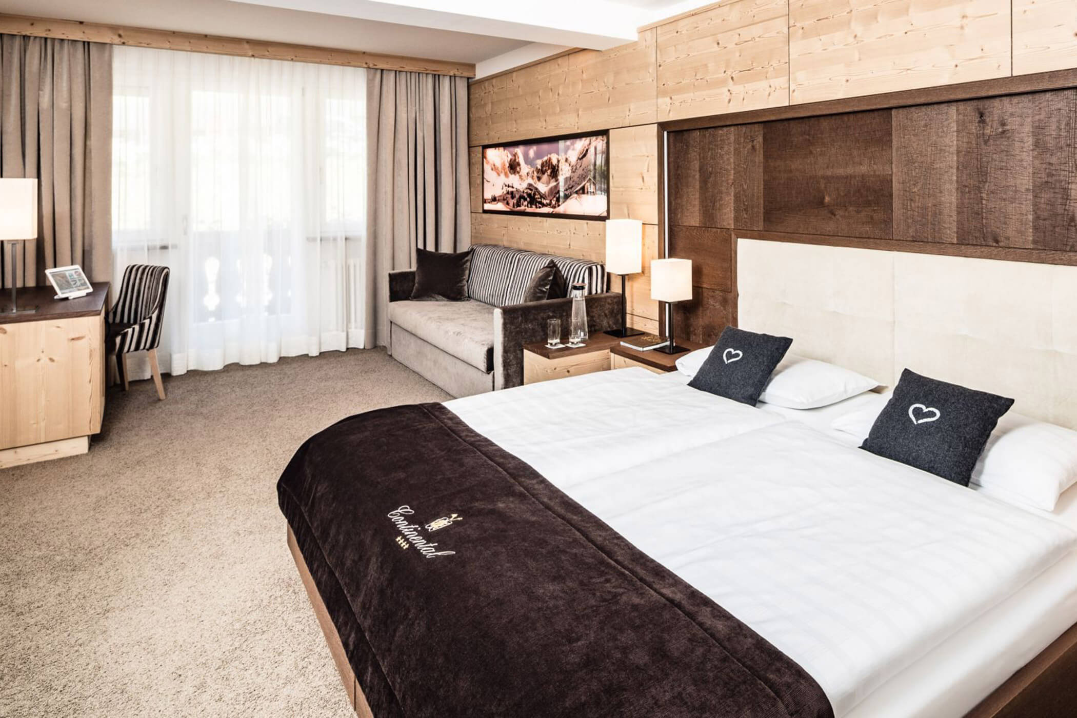 Classic double room superior with carpeted floor and a sofa in the background - Hotel Continental