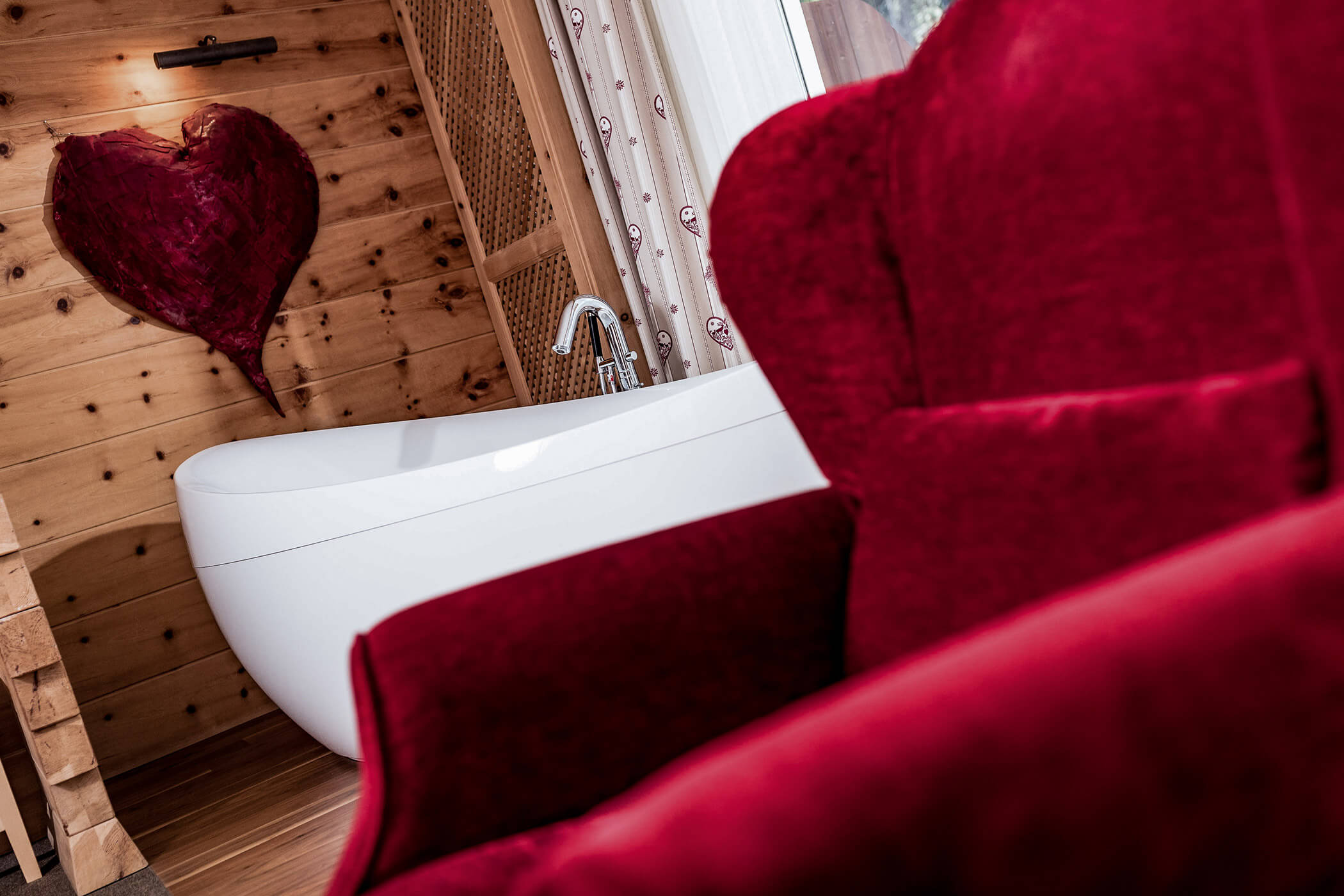 Red armchair with free-standing bathtub in the Classic Junior Suite 