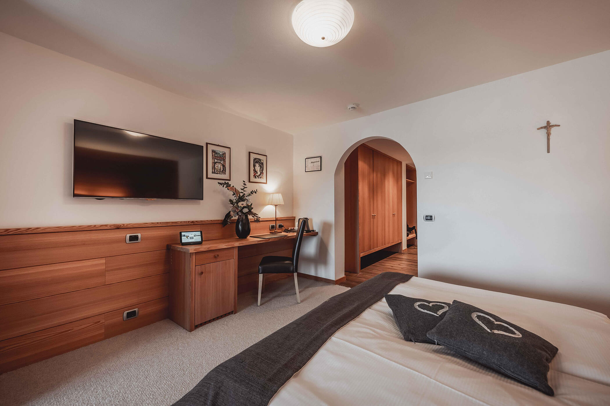 Double bed with light carpeting and TV in the Classic Junior Suite 