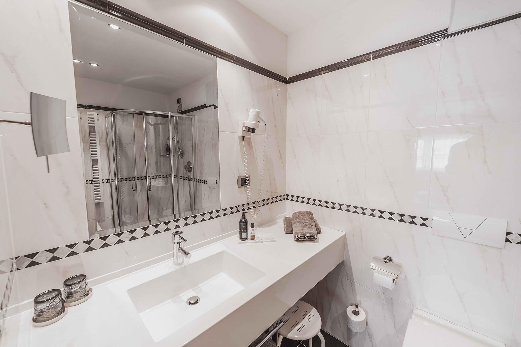 Bright bathroom with shower and washbasin in the Classic Junior Suite 