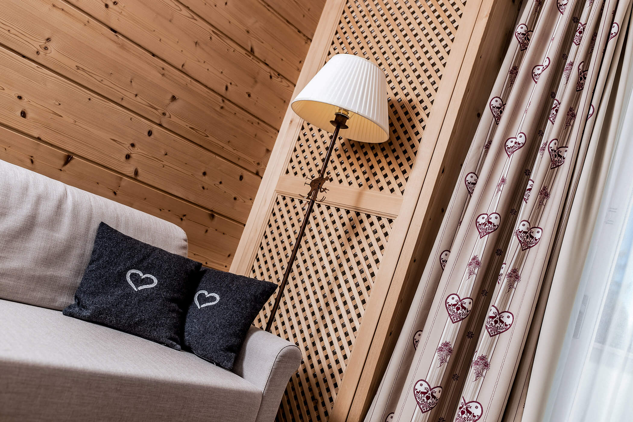 Lamp and gray couch with dark cushions in the Classic Junior Suite 