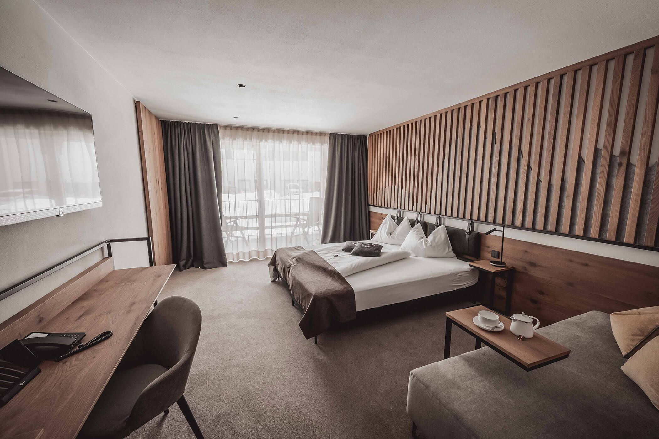 Double bed in Superior double room with desk and TV above - Hotel Continental