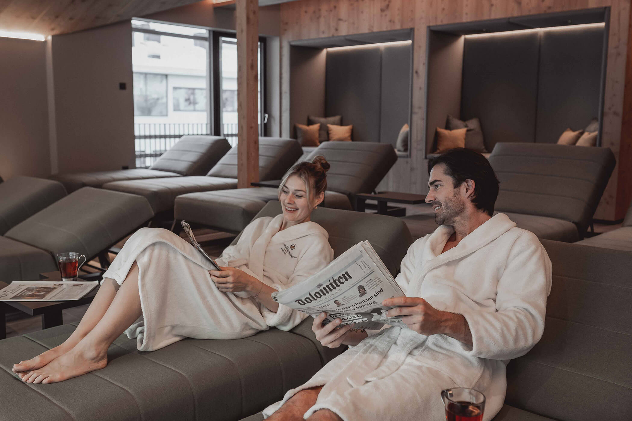A couple relaxes in the relaxation room and reads the newspaper - Hotel Continental