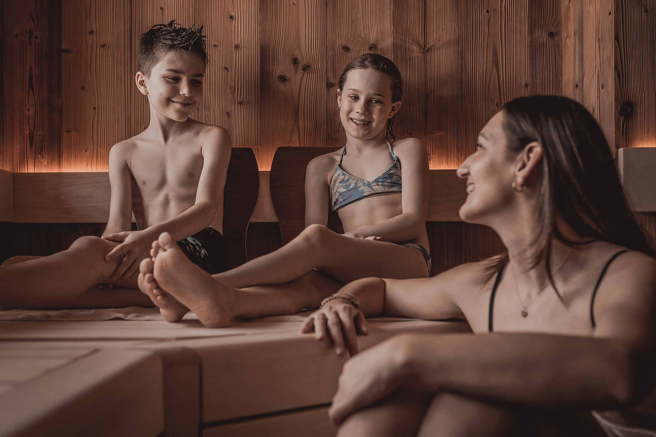 Two children and a woman sitting in the sauna - Hotel Continental