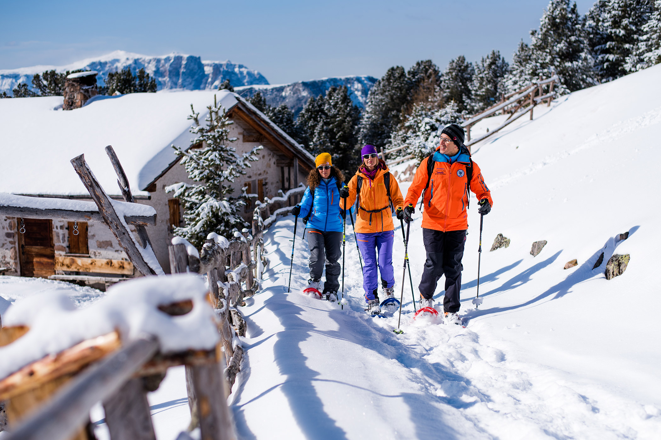 Three snowshoe hikers and snow-covered mountains in the background - Hotel Continental