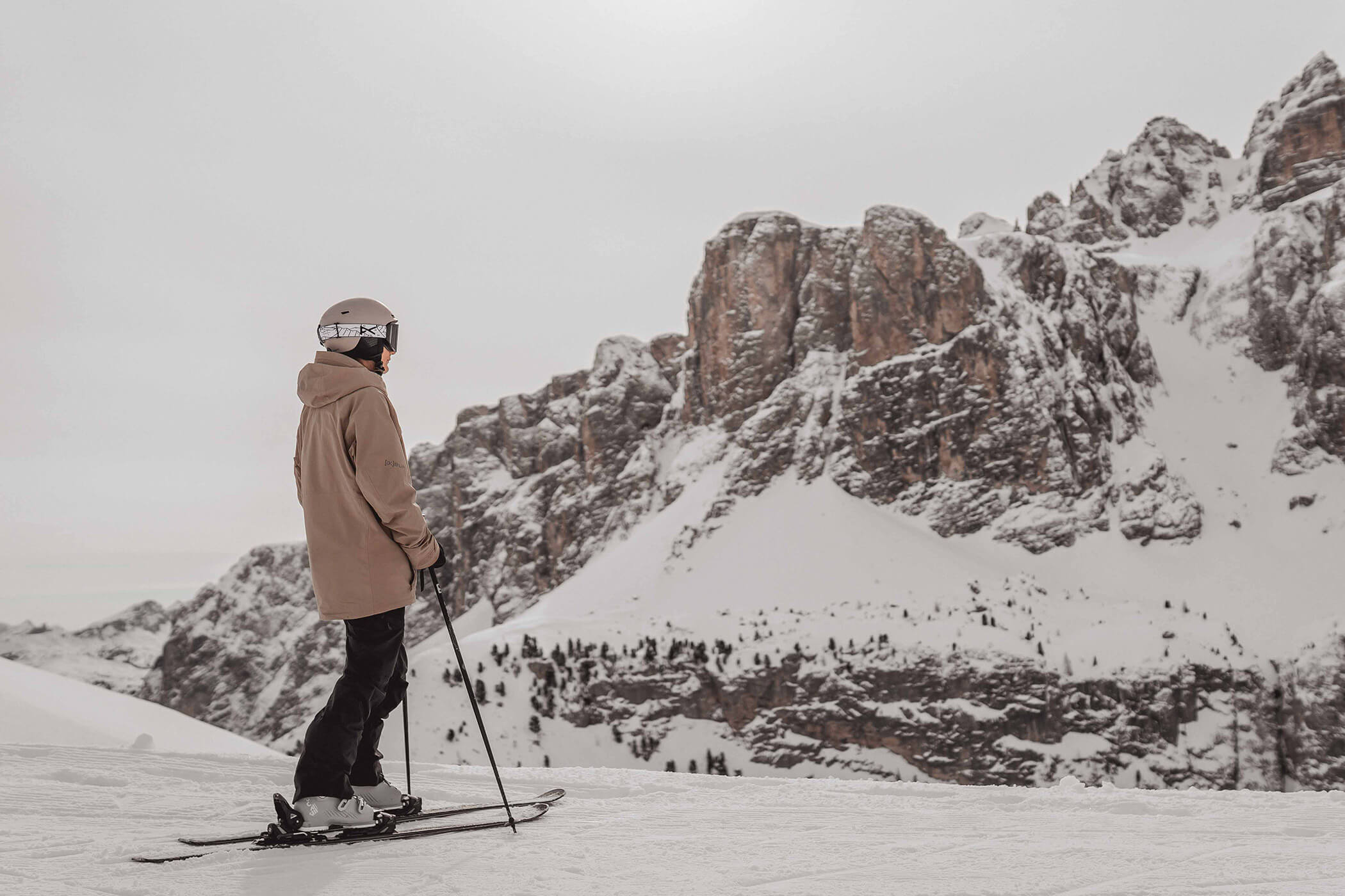 A skier stands on the slopes of the Sella Ronda looking at the surrounding mountains - Hotel Continental